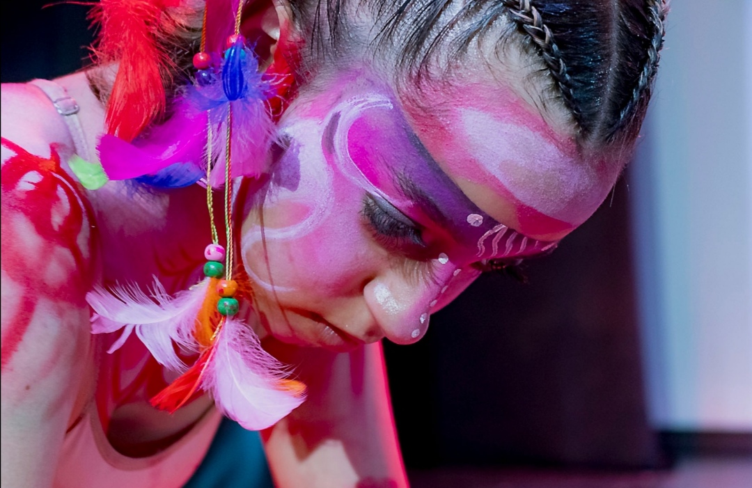 Dancer with feathered headpiece and tribal face paint