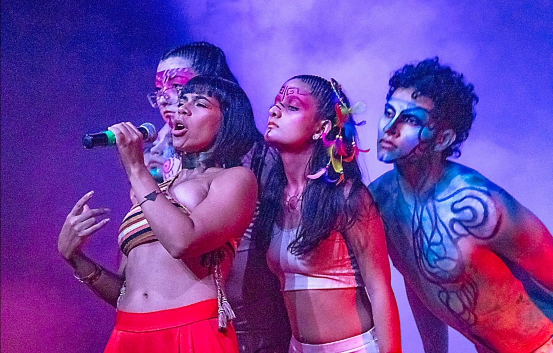 Academy performers singing on stage with tribal body paint